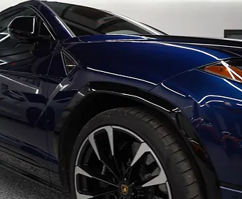 Close-up of a dark blue Lamborghini Urus front fender and wheel