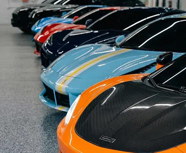 Row of exotic cars lined up in the Dynasty showroom