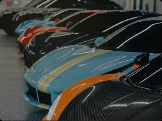 Close-up of exotic supercars lined up in the Dynasty showroom, ready for delivery